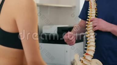 脊椎治疗-医生在手术前检查年轻妇女-显示脊柱上的问题